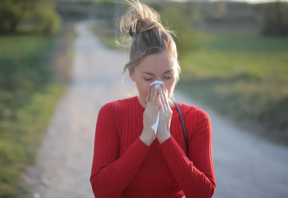 Frau mit Taschentuch hat eine allergische Reaktion